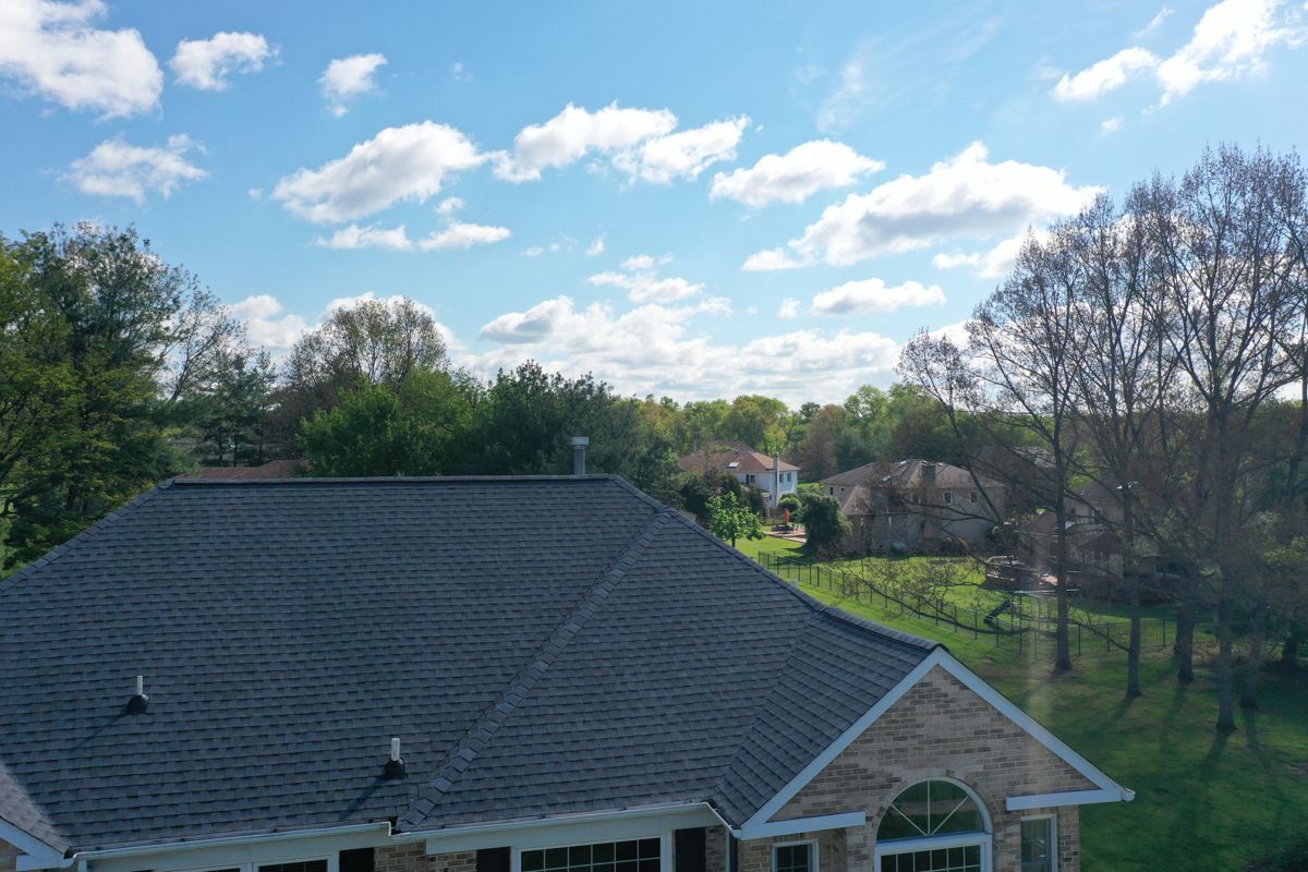 Finished dark gray shingle roof on a large brick-front colonial in Blue Bell, PA