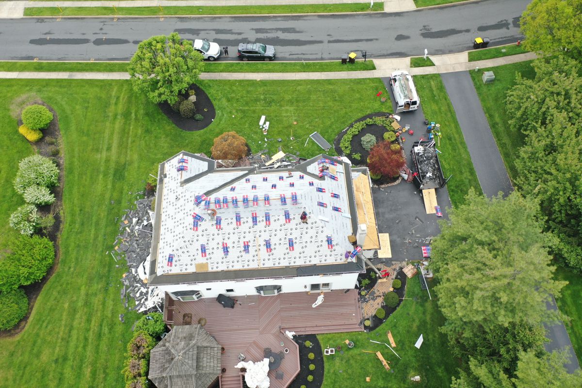 Drone view of a roof in Blue Bell, PA covered in GAF underlayment with shingle bundles staged