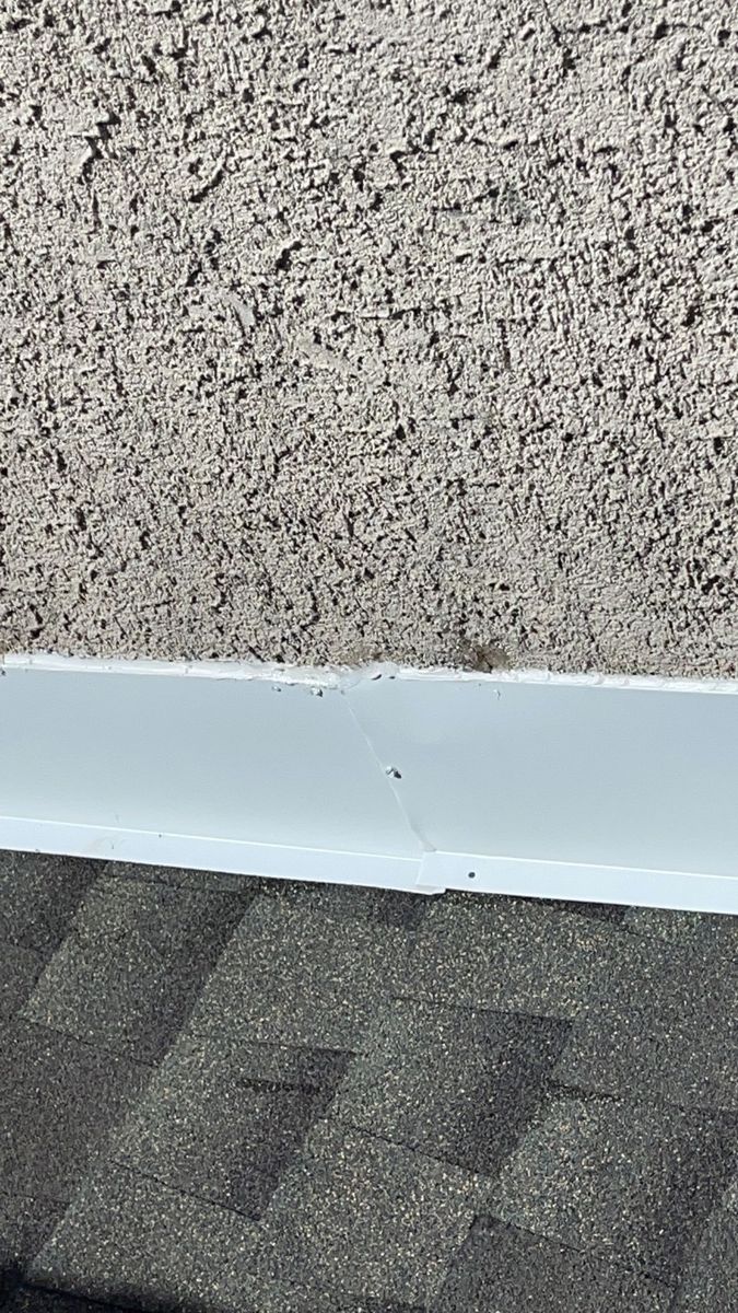 New shingles and new metal flashing where a roof meets a stucco wall in Ambler, PA