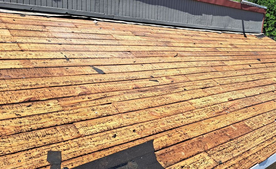 Old roof torn off down to the plank boards on a single-story building on East Street Road