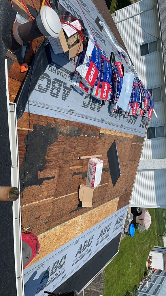 New decking and synthetic underlayment going down with GAF shingles staged on the roof in Somerton