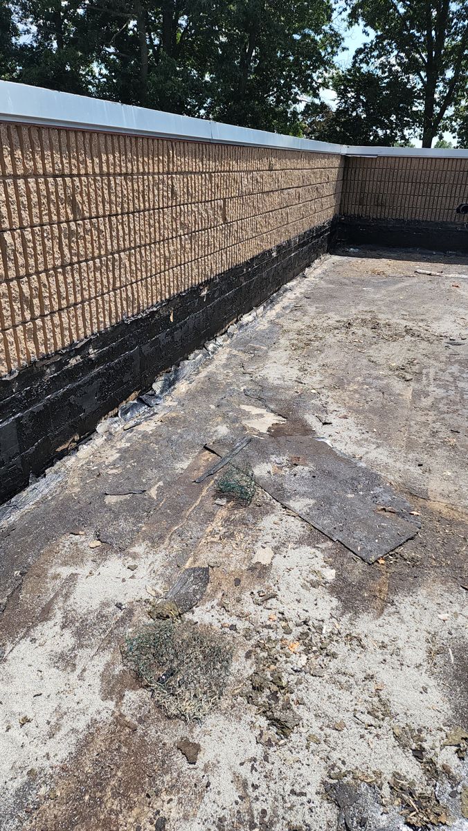 Worn old built-up commercial flat roof along a parapet wall in Northeast Philadelphia