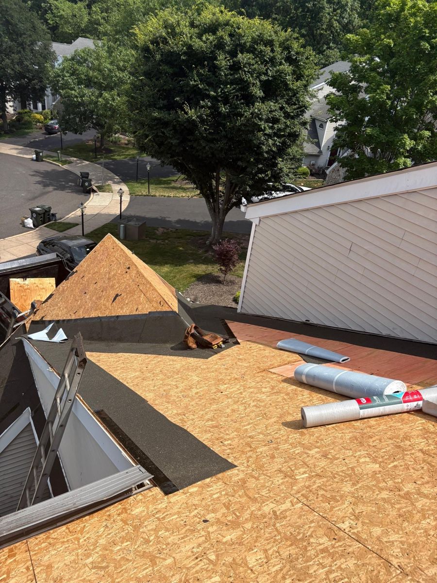 Leak barrier along a dormer and wall, new decking and rolls of GAF synthetic underlayment on a Doylestown roof