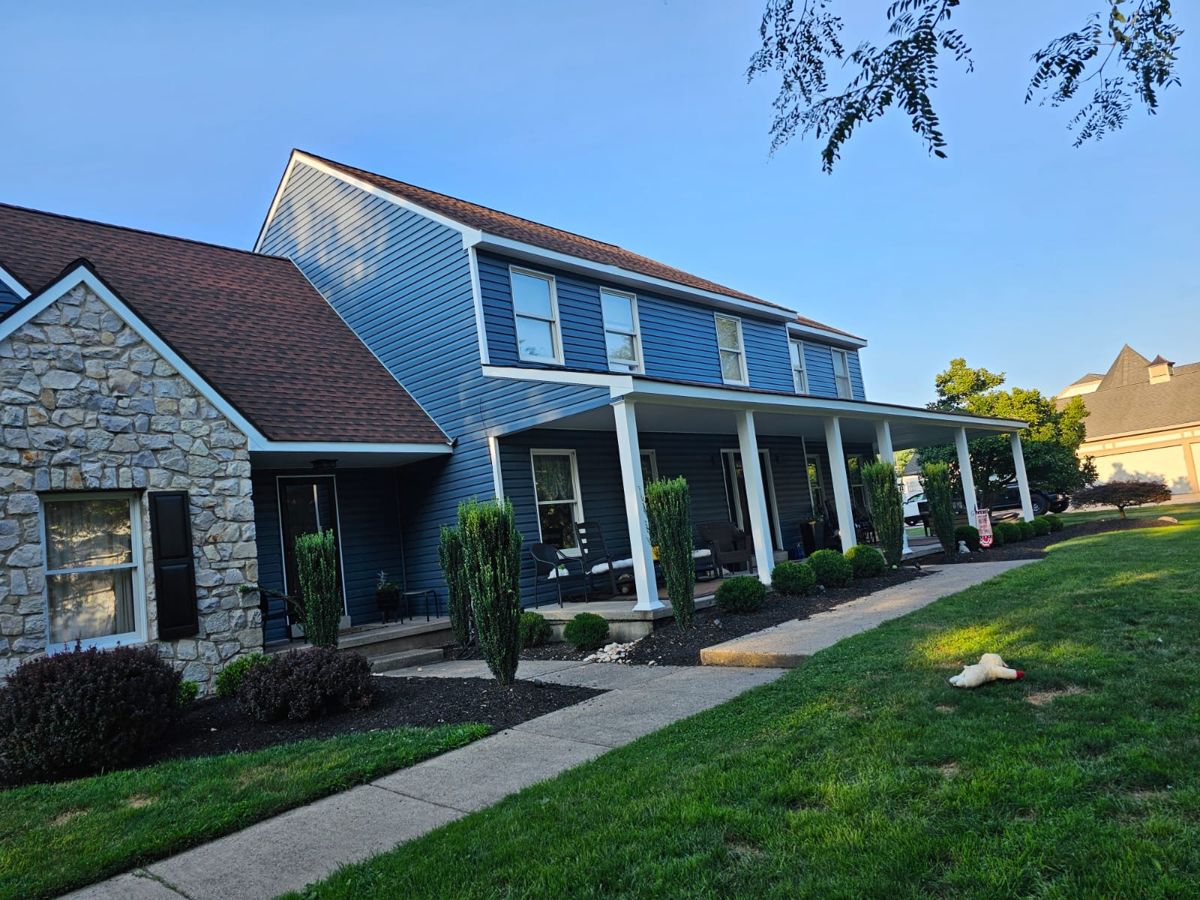 The same Langhorne home finished in blue siding with white trim and white porch columns