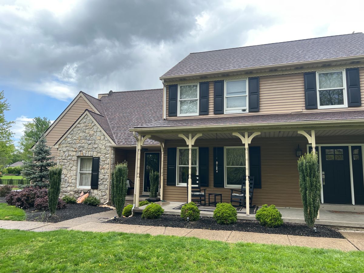 Tan vinyl siding and wood porch posts on a Langhorne colonial before the exterior work