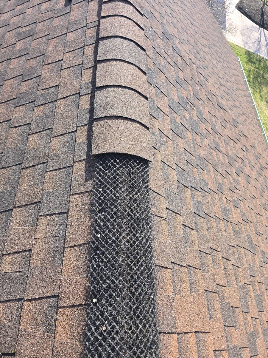 Ridge cap shingles being laid back over a ridge vent on a Langhorne roof