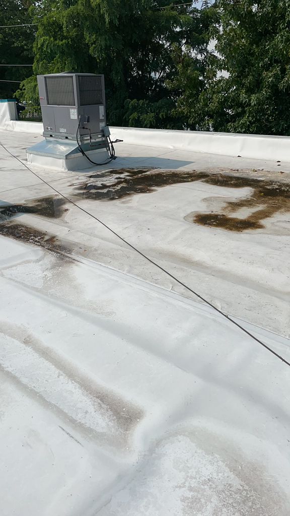 Stained TPO flat roof with a rooftop HVAC unit on a commercial building in Fairless Hills, PA
