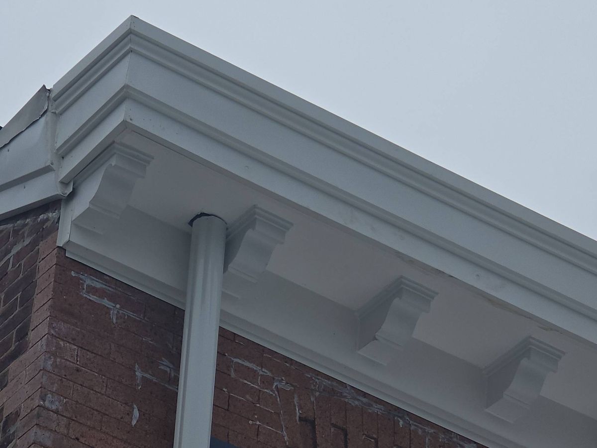 Rebuilt white cornice with decorative brackets on a brick rowhome in Manayunk