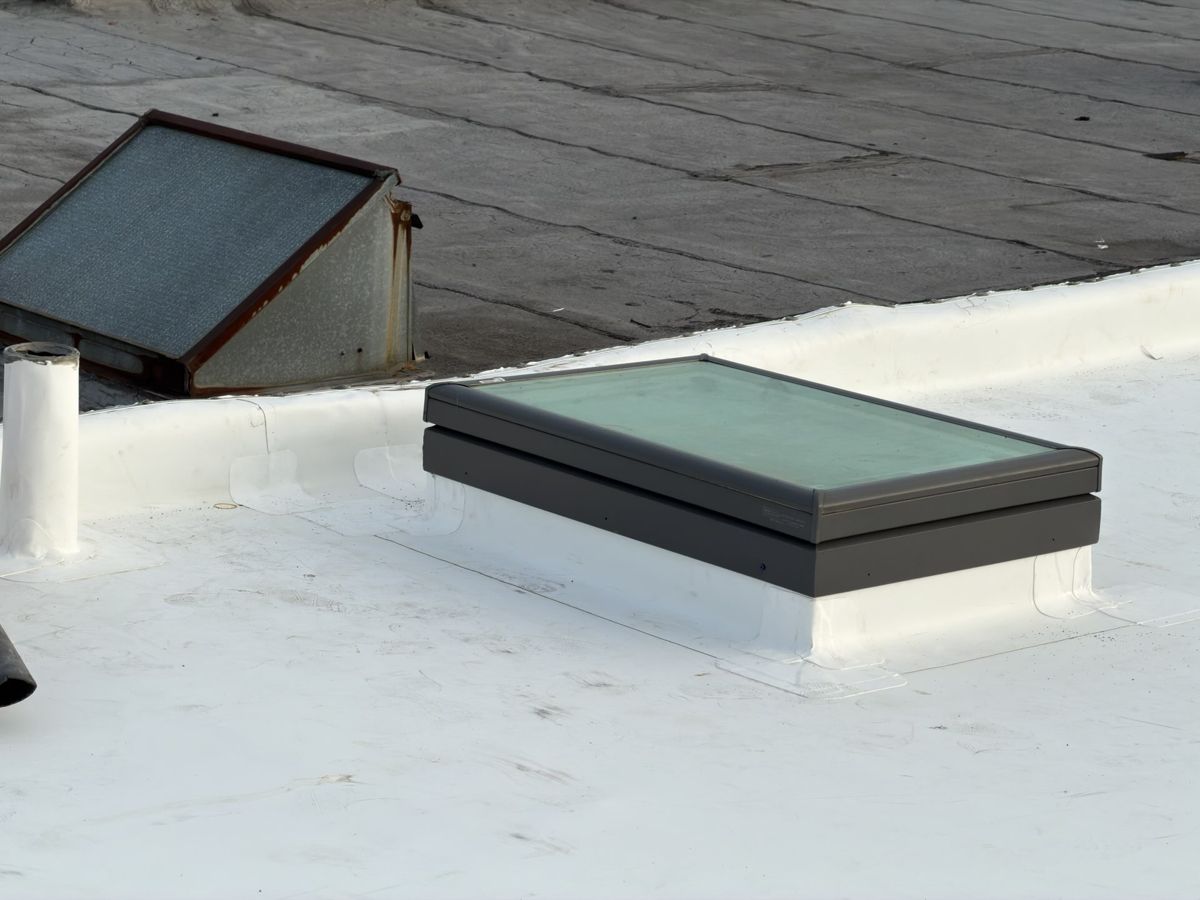 Skylight on a rebuilt curb set into a new white flat roof in Roxborough, Philadelphia