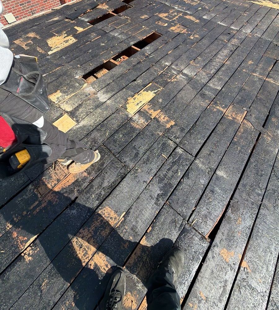 Old board roof deck with rotted and missing boards on a Roxborough rowhome