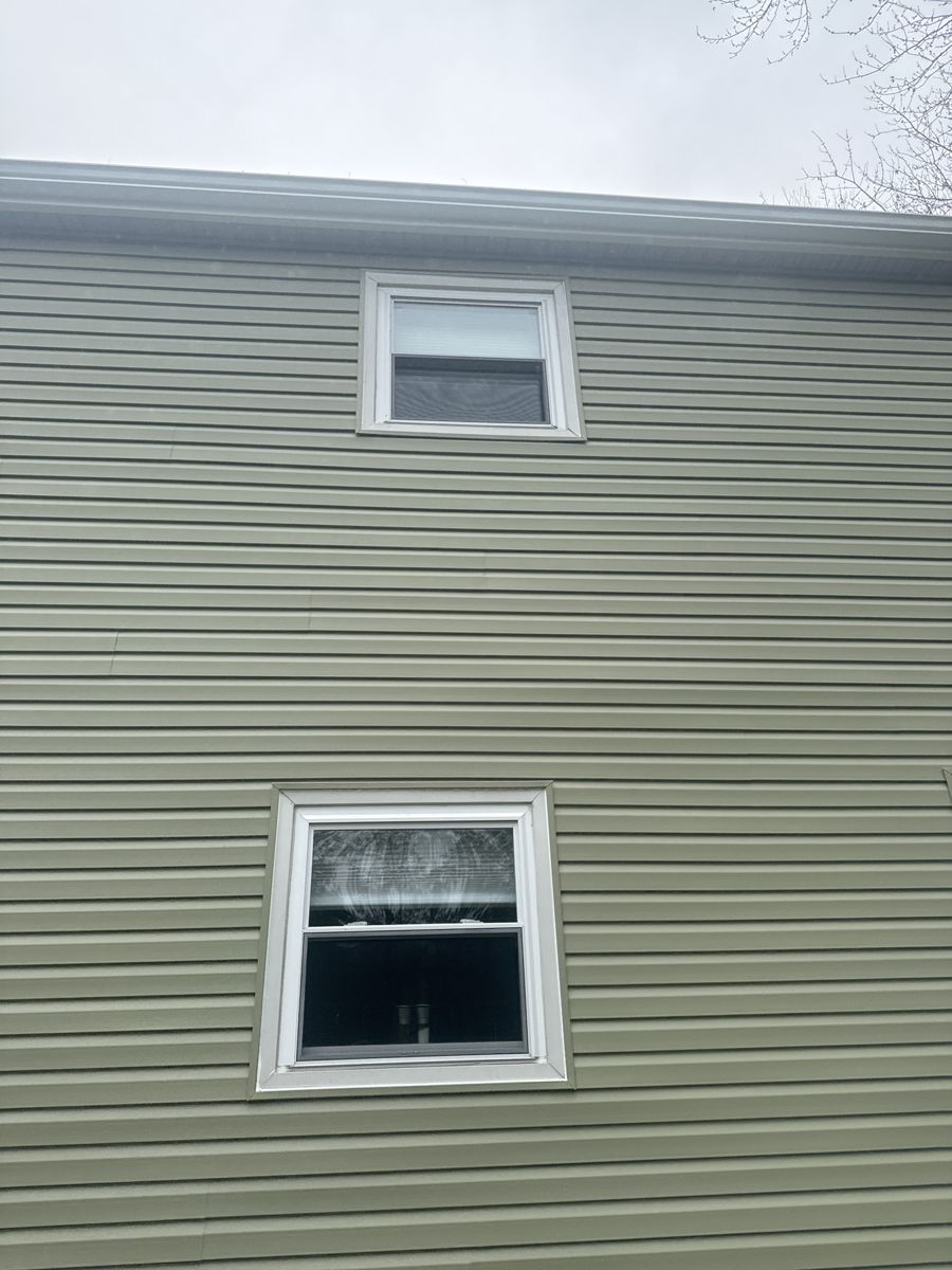 New sage green vinyl siding, window trim and gutter on a Morrisville home