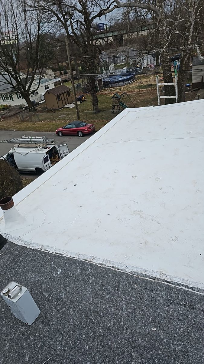 New white membrane on a low-slope roof above new dark shingles in Morrisville