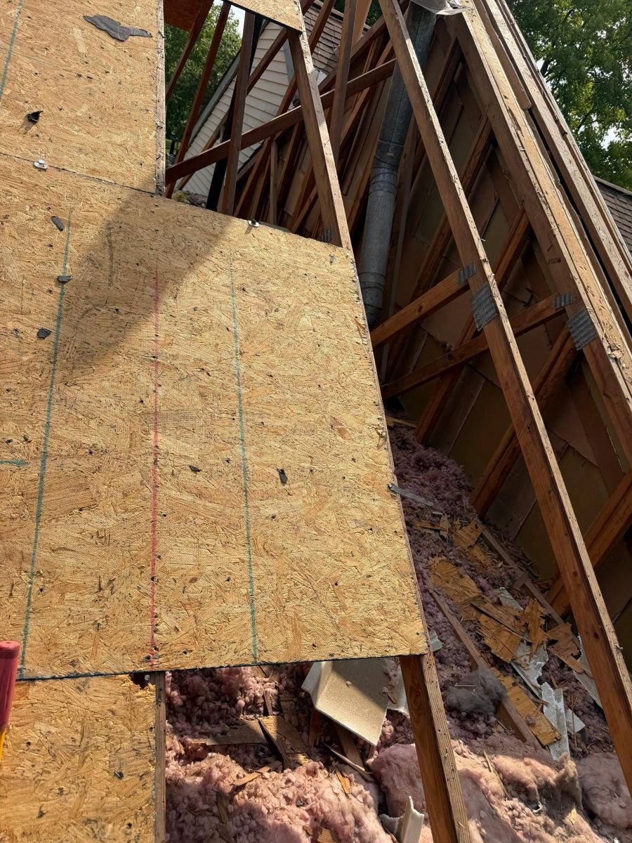 New roof sheathing going on over open rafters during a Newtown roof replacement