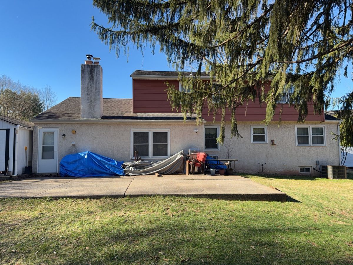 Two-story home with red upper-story siding and a worn roof in Lansdale, PA