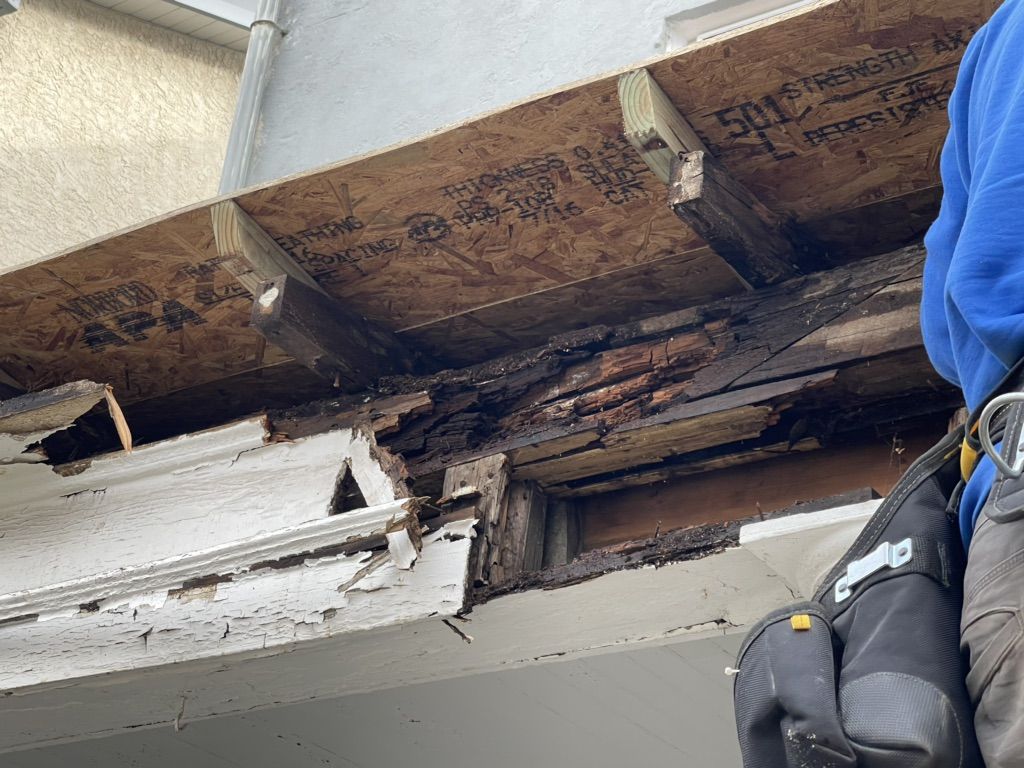 Rotted porch roof framing opened up beside new lumber on a home in North Wales, PA