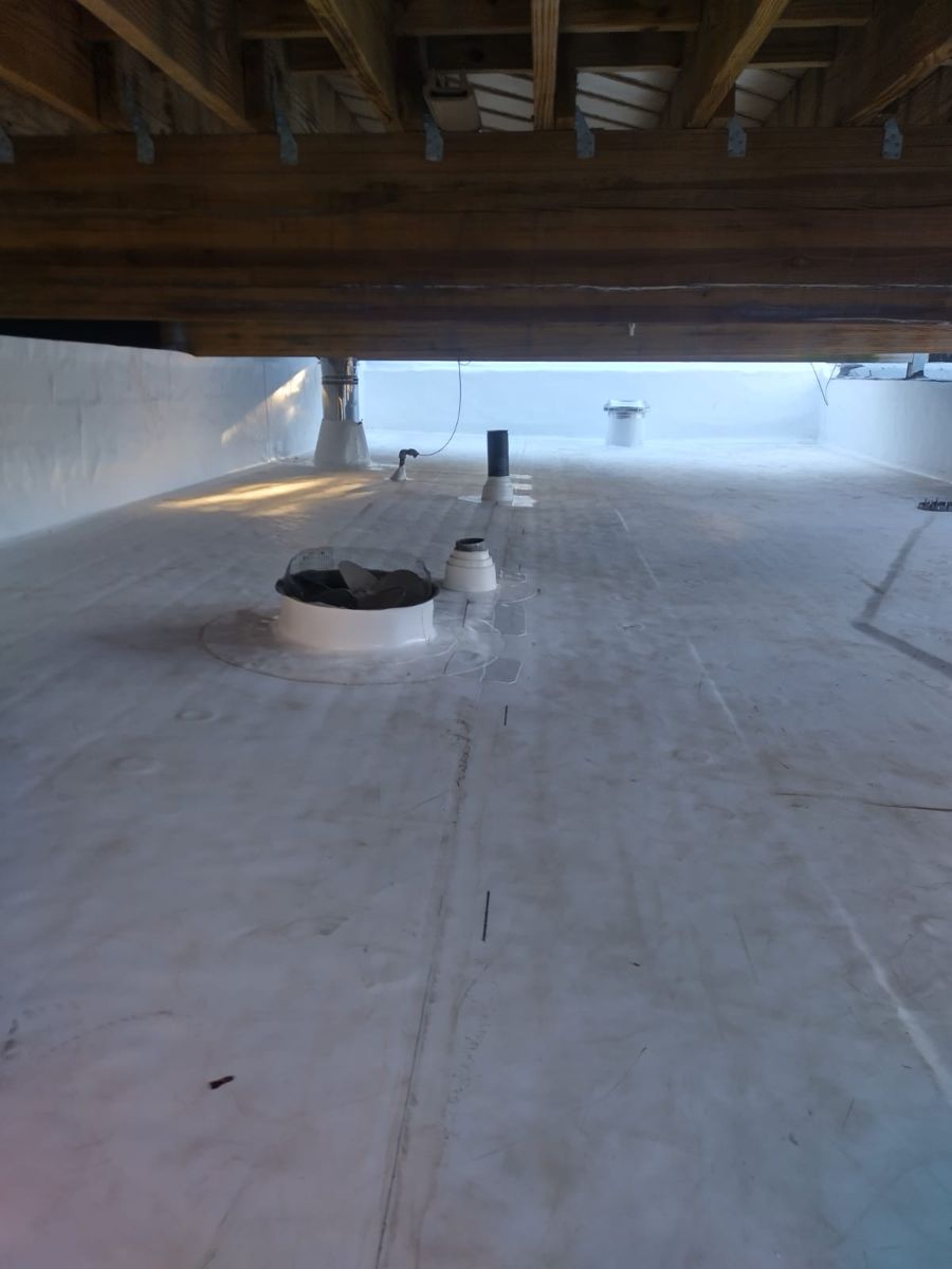 New white flat roof beneath the framing of a rooftop deck on a Philadelphia rowhome