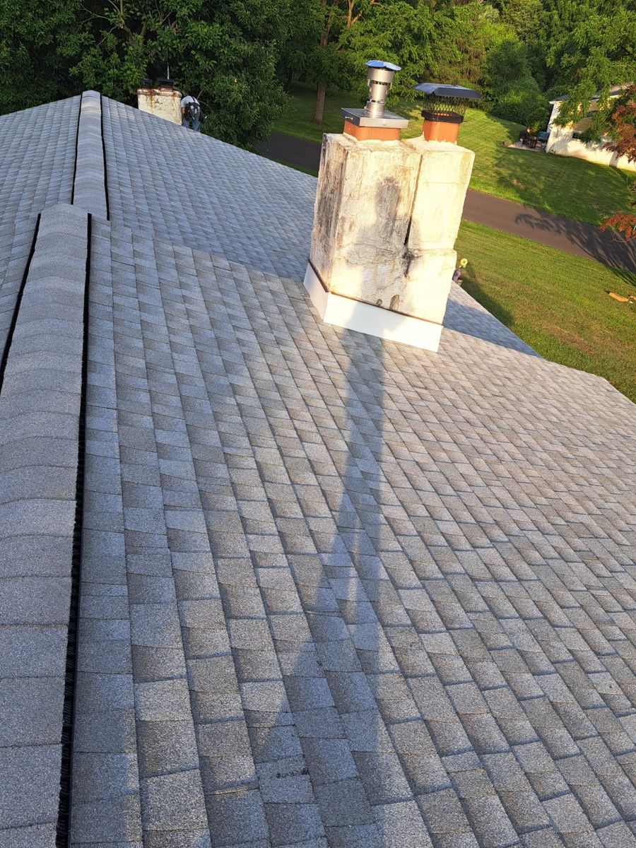 Finished gray GAF Timberline HDZ roof with ridge vent and chimney in Churchville, PA