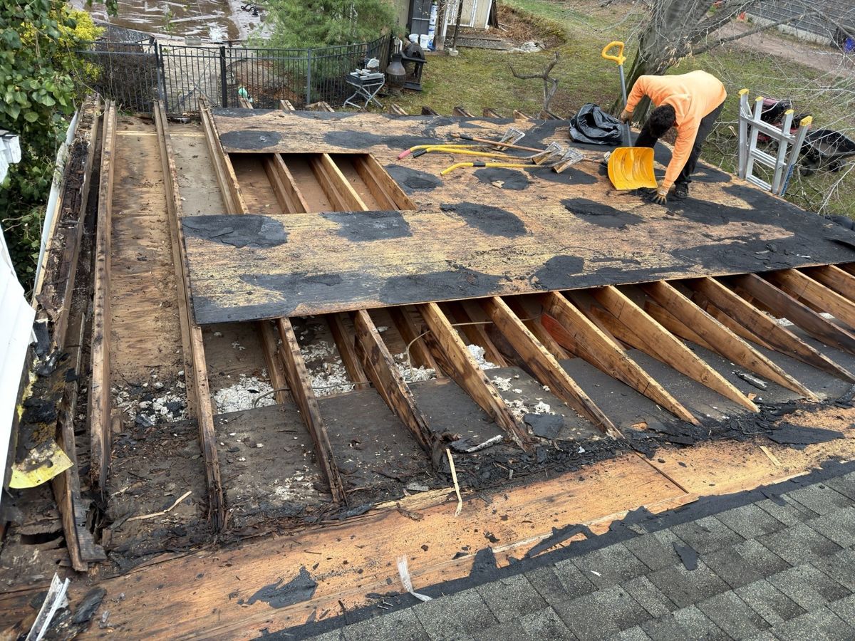 Flat roof stripped to its joists next to a shingle roof in Holland, PA