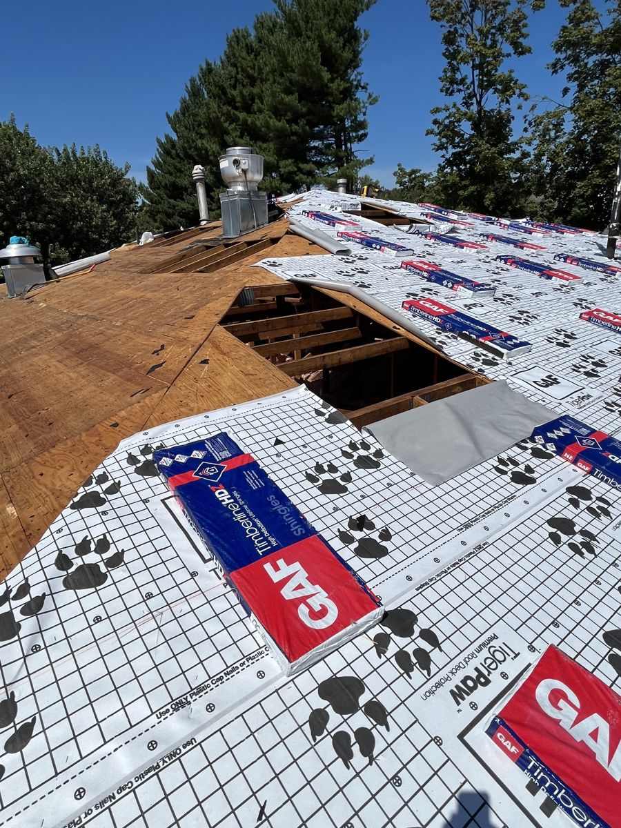 GAF Tiger Paw underlayment and Timberline HDZ shingle bundles on a commercial roof