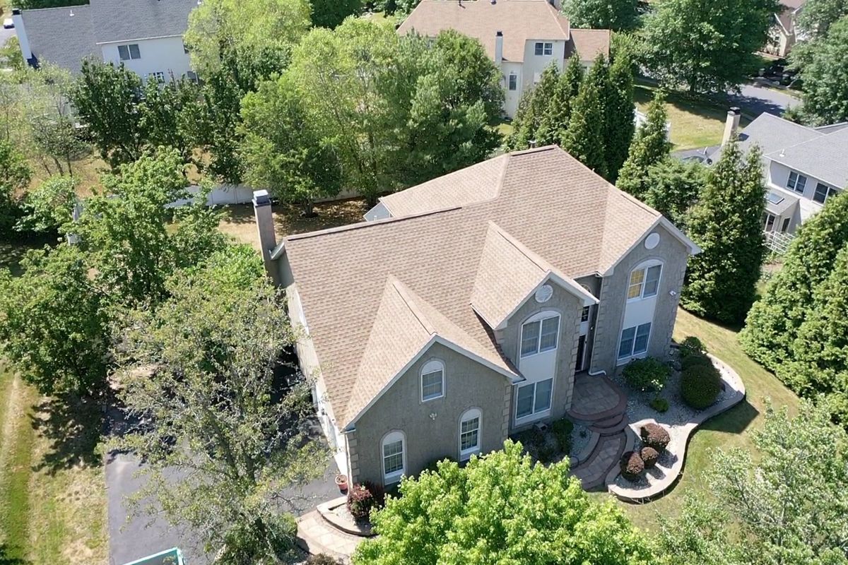 Aerial view of a finished tan GAF Timberline HDZ roof on a two-story Southampton home