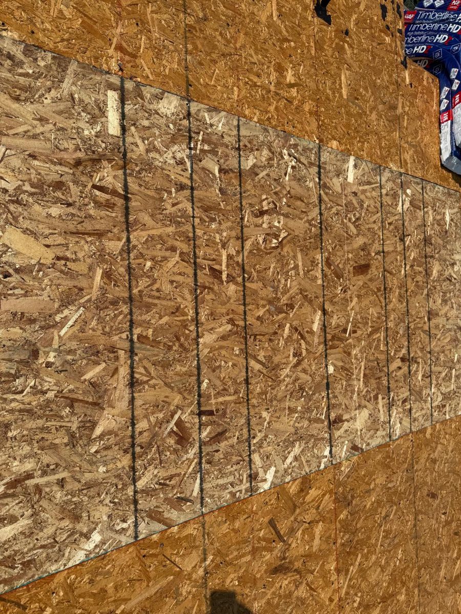New OSB decking panels installed on a Southampton townhouse roof beside bundles of GAF Timberline HDZ shingles