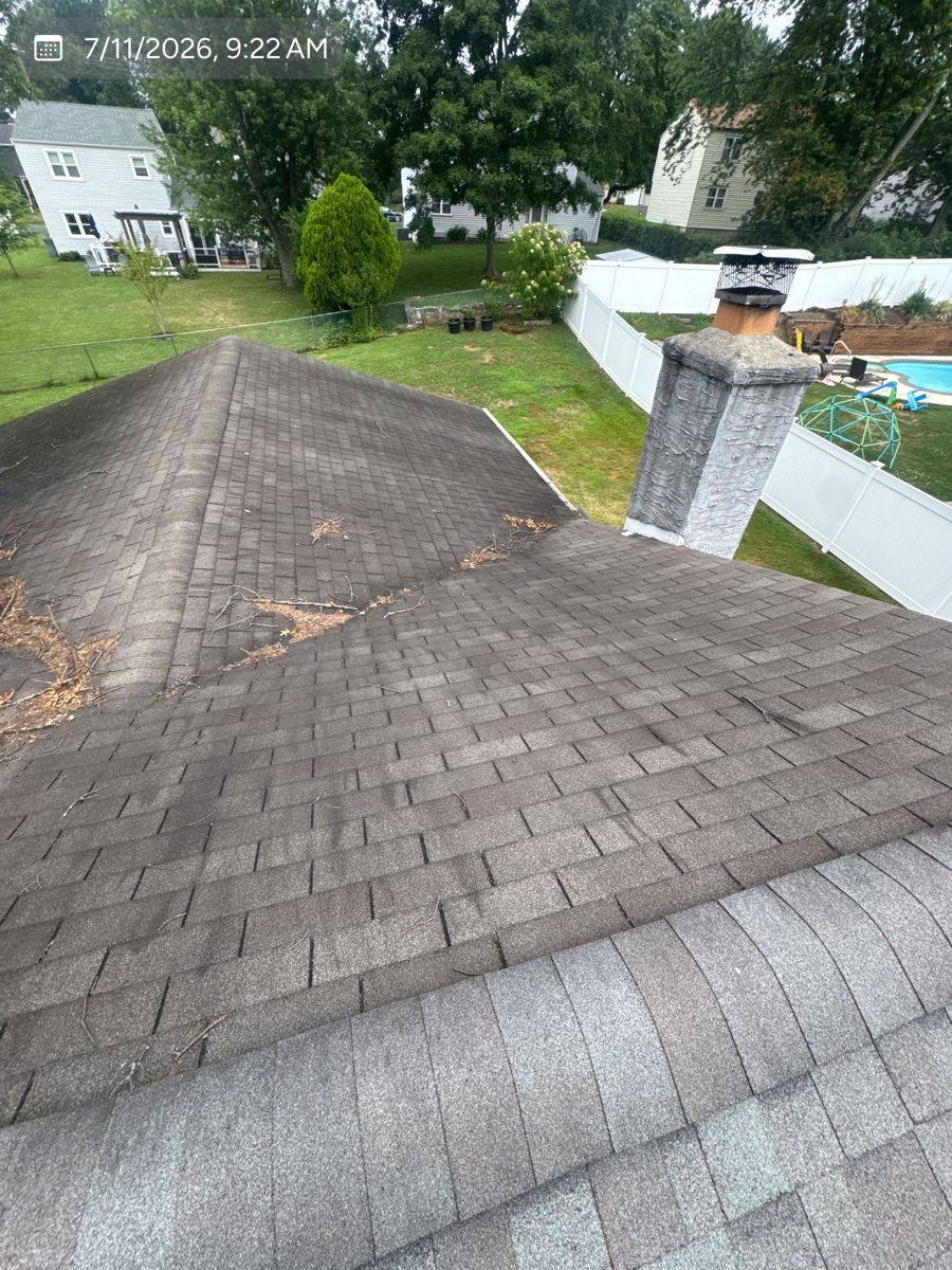 Stained, aging shingles and chimney on a Warminster roof before replacement