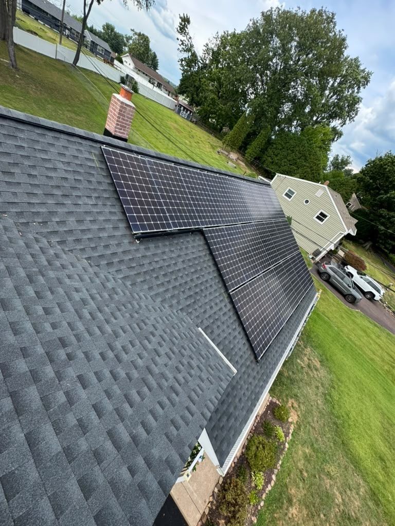 New charcoal GAF Timberline HDZ roof with solar panels reinstalled