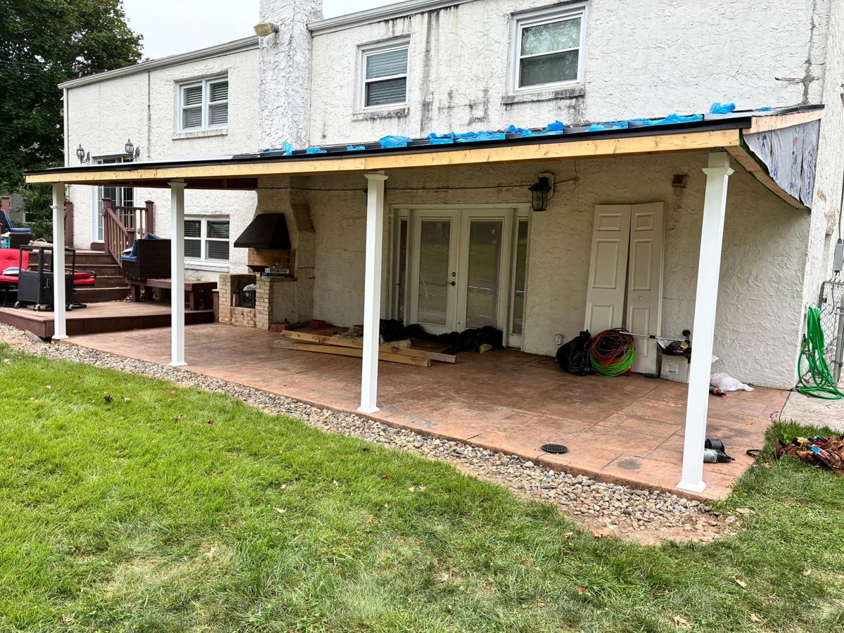 Rebuilt covered patio roof with dark metal fascia on a Warminster home
