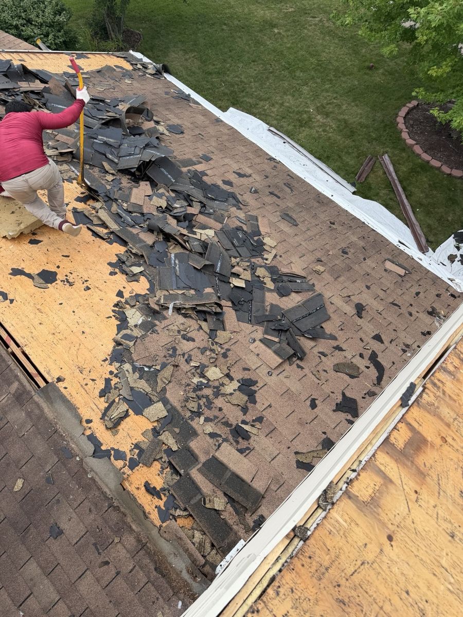 Crew tearing off two layers of old shingles from a roof in Chalfont, PA