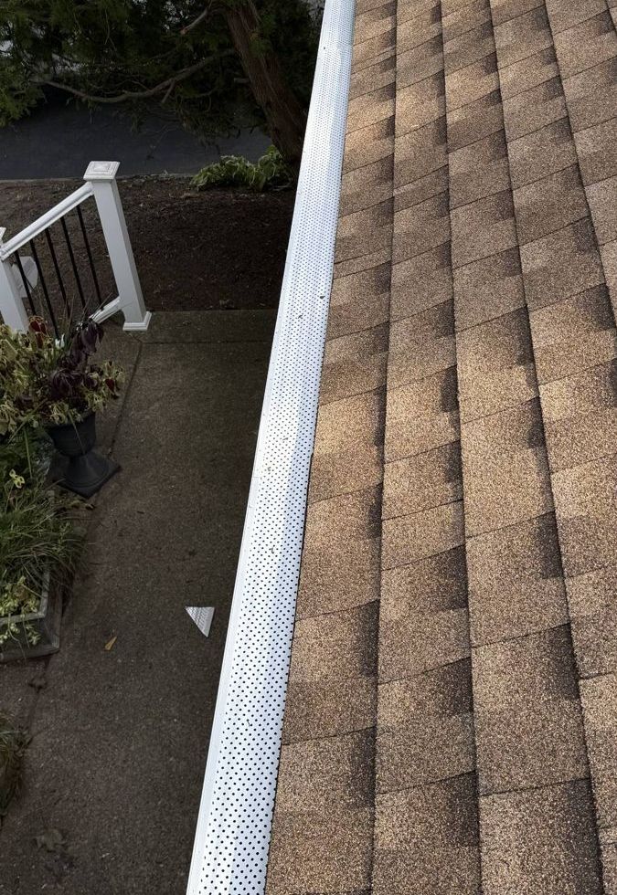 New shingle roof edge with a white seamless gutter and gutter guard in Abington, PA